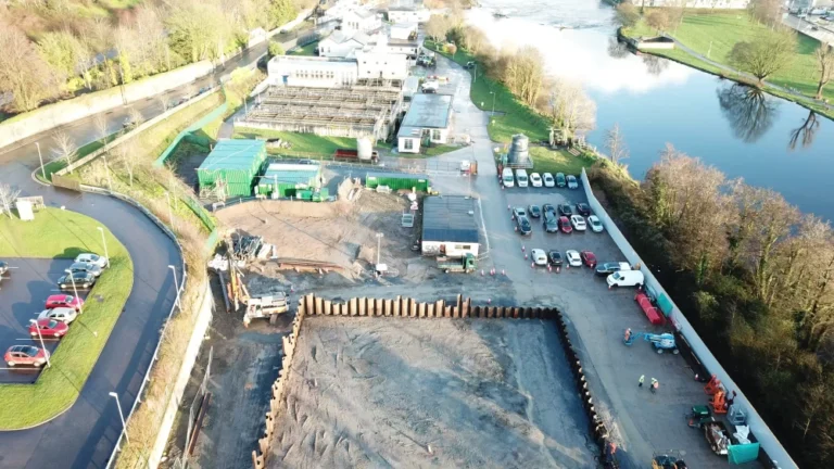 An aerial view of the Lee Road Water treatment plant construction site surrounded by cars and a river.