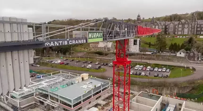 A Murphy branded crane on a construction site with houses and cars in the background.