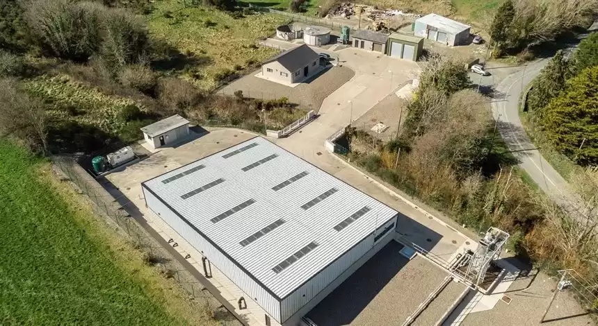 A water treatment plant next to a road and surrounded by fields.