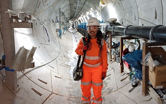A Murphy employee wearing a high-visibility uniform with a white helmet in a construction tunnel.