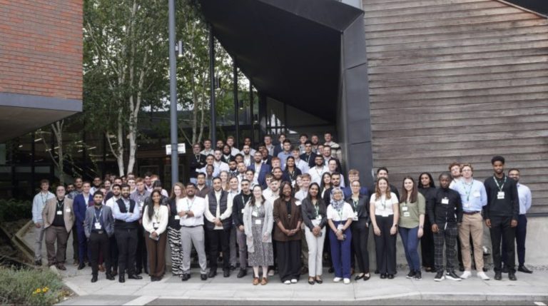 A group of Murphy employees and graduates stood in front of a building smiling for a photo.