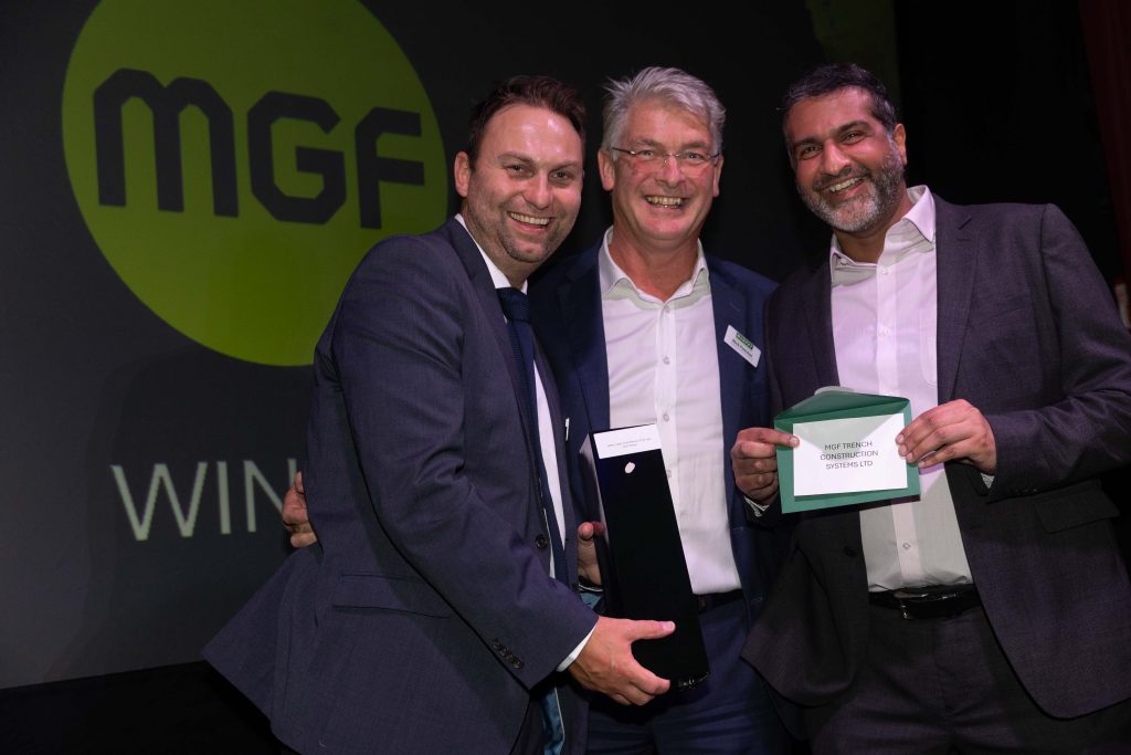 Three people in business dress celebrating an award win at Murphy's annual Supplier Awards.