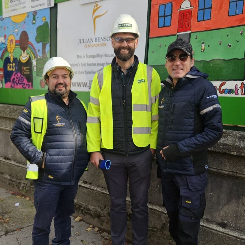 Three people wearing Murphy uniform smiling with art in the background.