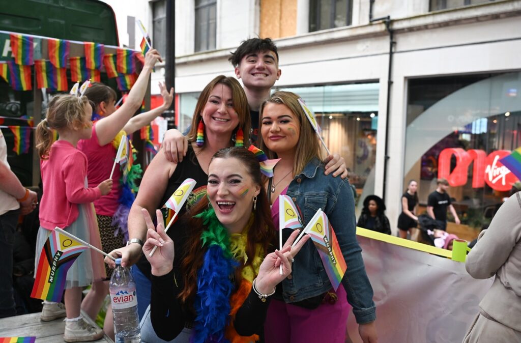 Four people smiling at a stood on a Murphy branded truck at a Pride event