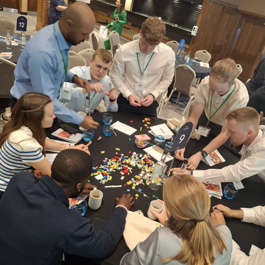 A group of people in business dress with building blocks at a table.