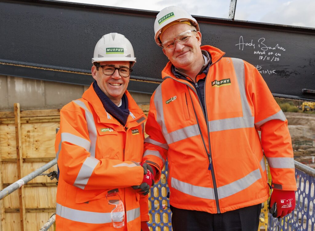 Two people in orange Murphy uniform shaking hands at a construction site.