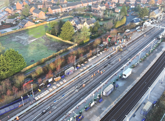 A railway station under construction surrounded by houses on one side.