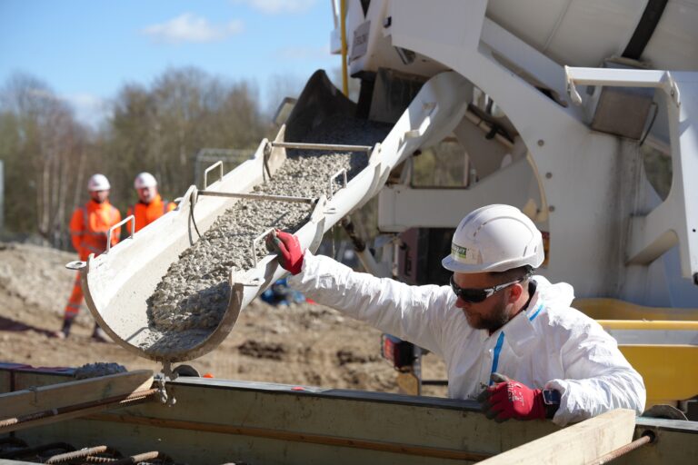 A Murphy employees dressed in safety uniform assisting with a concrete pour at Shipley Depot project site.